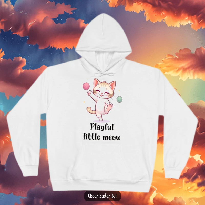 Funny playful kitten performing a high kick with sparkling pom-poms, wearing a cozy hoodie.