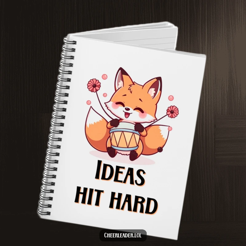 Funny fox playing a tiny drum with pom-poms, adorned on a notebook for capturing creative and musical thoughts.